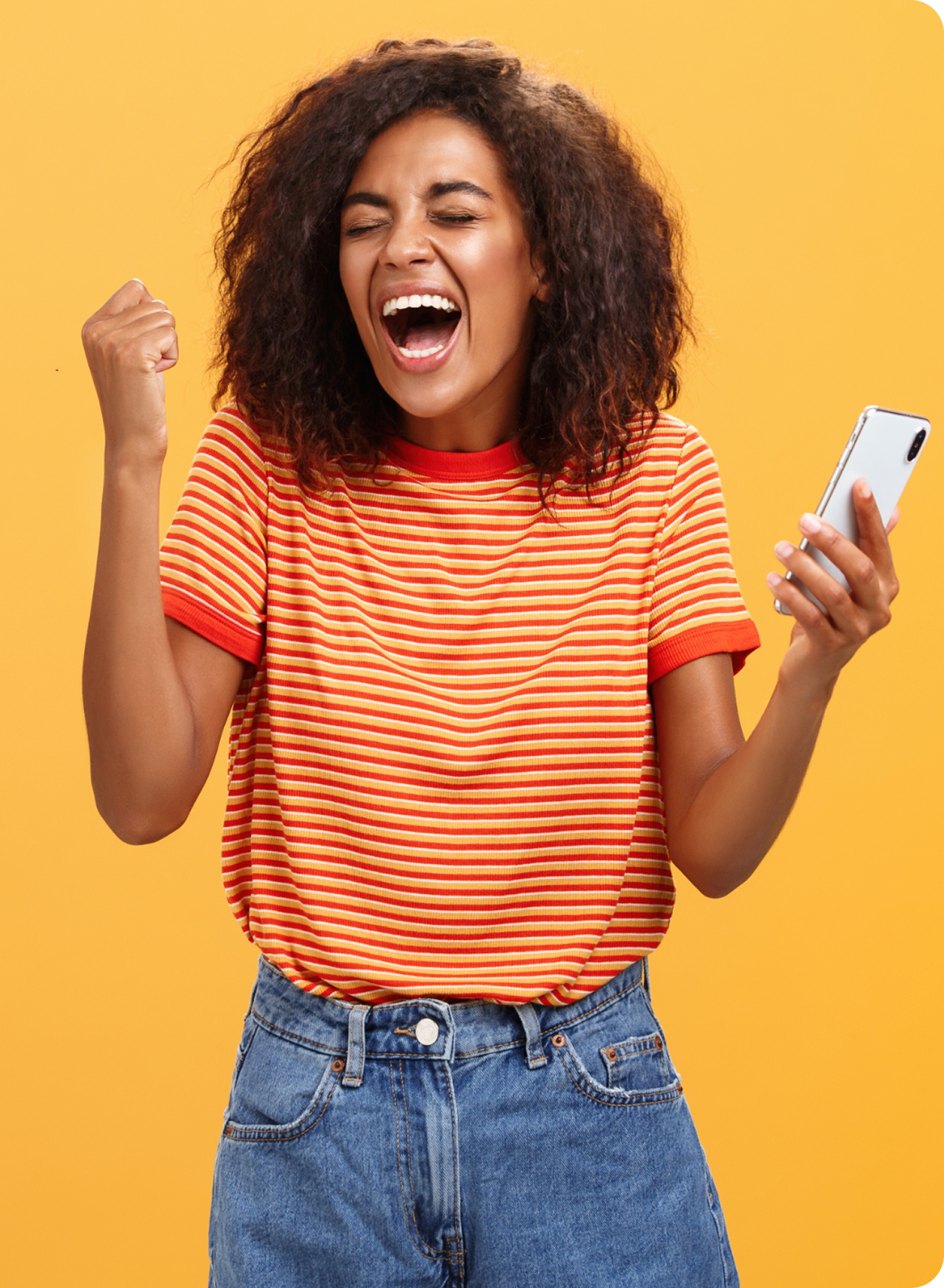 A lady wearing an orange striped top is holding a mobile phone and has an excited expression on her face